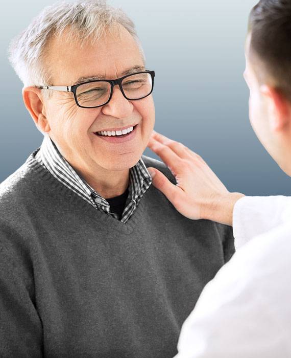 Mature male patient smiling while being comforted by doctor | Internal Medicine & Wound Care